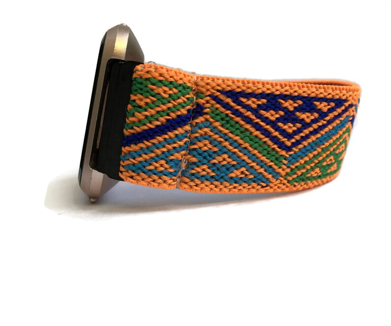 Peut inclure: Gros plan d'une montre avec un bracelet argent&eacute; et un bracelet color&eacute; &agrave; motifs orange, bleu et vert.