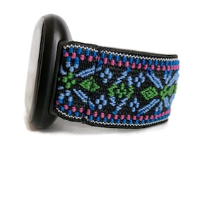 May include: A black watch band with a colourful geometric pattern in shades of blue, green, and pink.