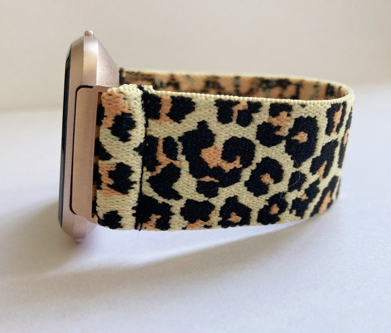 May include: A rose gold smartwatch with a leopard print elastic band.