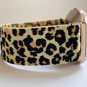 Peut inclure: Une montre connectée de couleur dorée avec un bracelet à imprimé léopard. Le bracelet est fait d'un matériau doux et extensible.