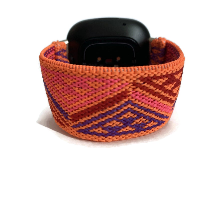 May include: Orange, pink, purple, and red woven watch band with a geometric pattern.