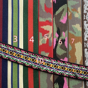 Op de afbeelding: Een verzameling kleurrijke geweven linten en banden. Ontwerpen omvatten strepen, camouflage, geometrische patronen en een gedetailleerde geborduurde rand. Kleuren variëren van groen, rood en blauw tot neutrale tinten, geschikt voor diverse knutselprojecten.