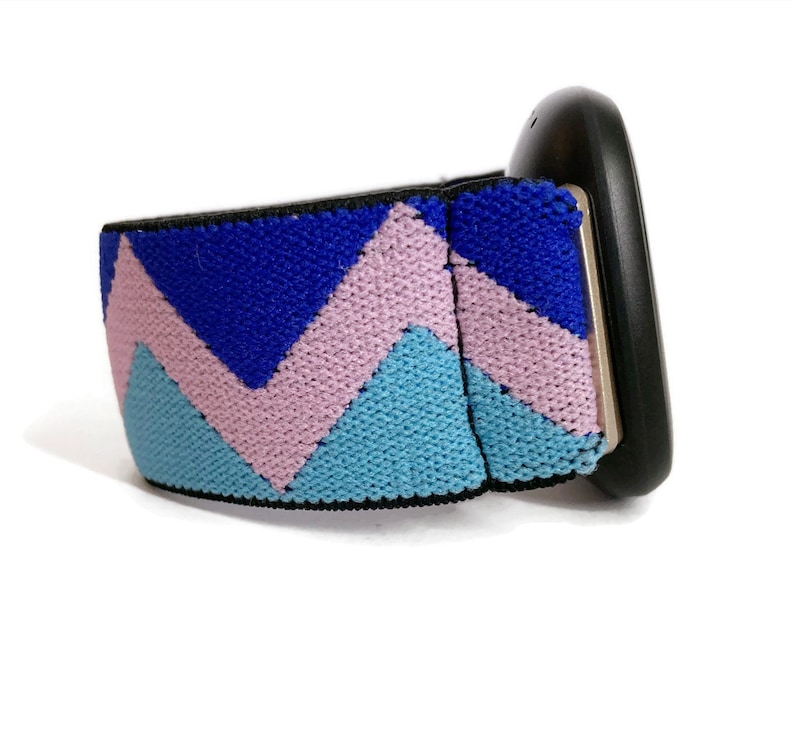 May include: A black watch with a blue, pink and light blue chevron patterned strap.