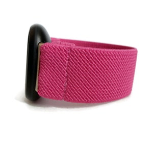 May include: A pink elastic watch band with a black metal buckle.