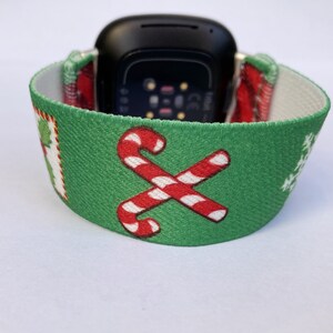 Puede incluir: Una banda de reloj de tem&aacute;tica navide&ntilde;a verde y roja con un dise&ntilde;o de bast&oacute;n de caramelo. La banda est&aacute; hecha de un material suave y el&aacute;stico y es compatible con la mayor&iacute;a de los relojes inteligentes.