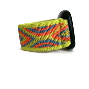 May include: A bright yellow watch band with a geometric pattern in orange and blue. The band is made of woven fabric and has a black buckle.