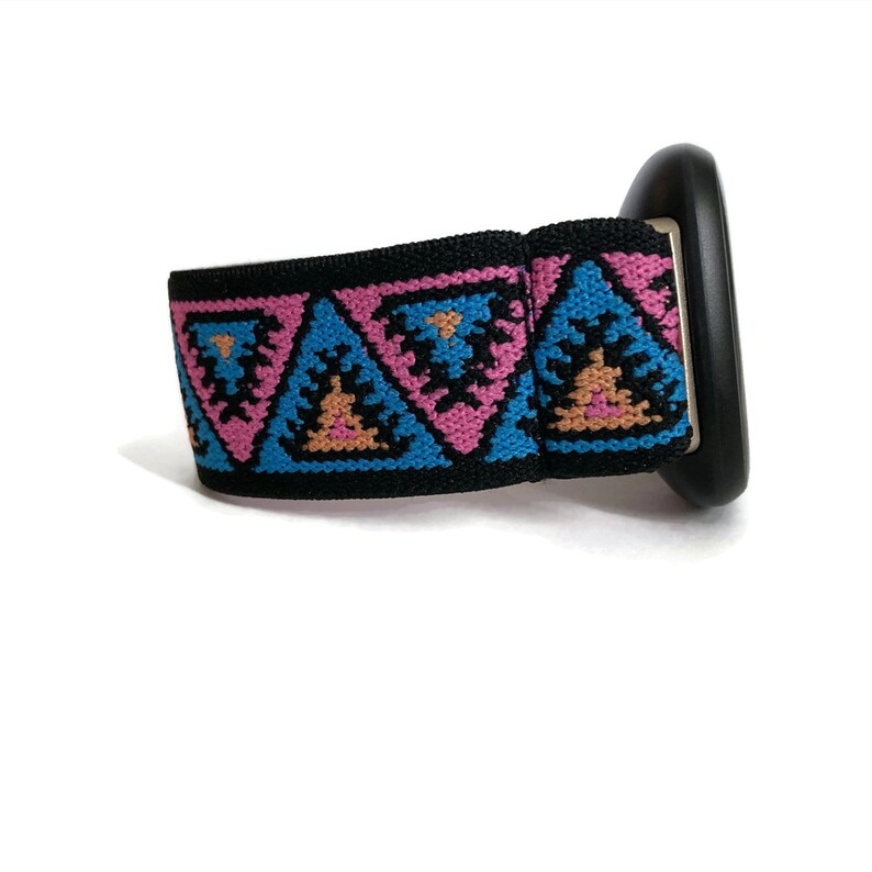 May include: A black watch band with a pink, blue, and orange geometric pattern.