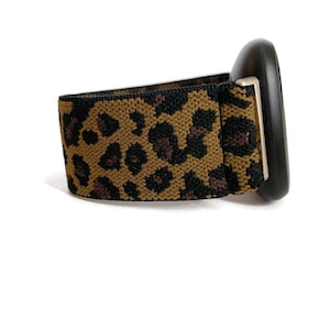 May include: A black watch with a leopard print elastic band.