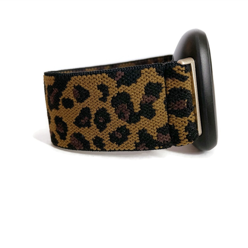 May include: A black watch with a leopard print elastic band.
