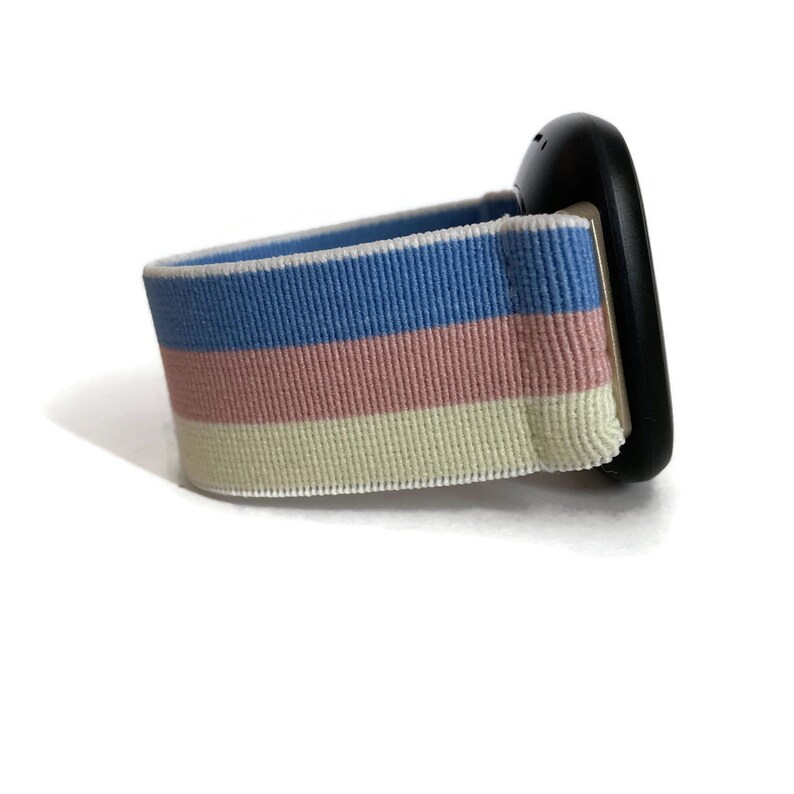 May include: A black watch with a striped blue, pink and cream coloured band.