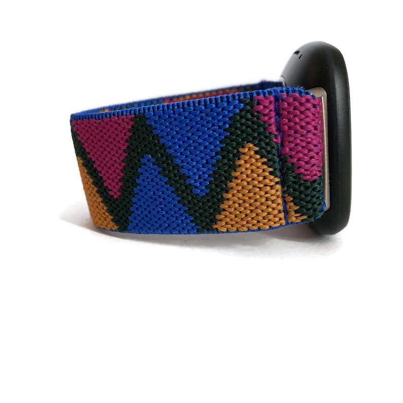May include: A colorful watch band with a geometric pattern in shades of blue, green, orange, and pink. The band is made of a stretchy material and has a black watch face.