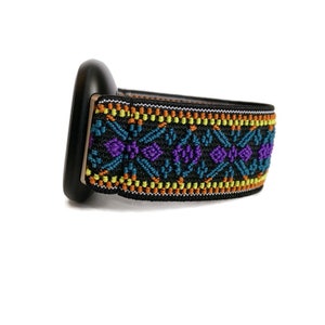 May include: Black watch band with a colorful geometric pattern in shades of orange, yellow, blue, and purple.