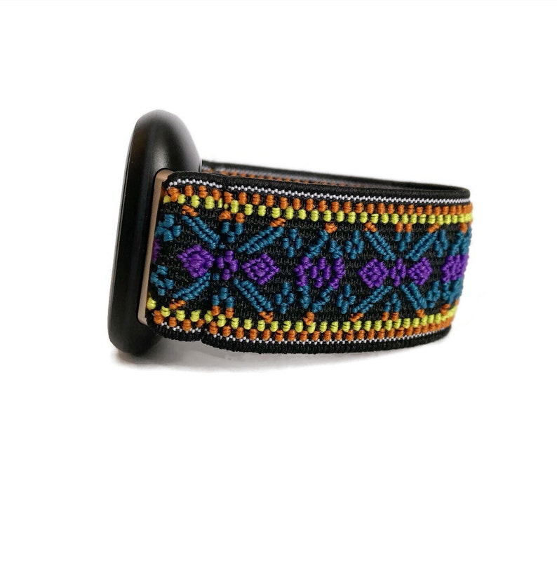 May include: Black watch band with a colorful geometric pattern in shades of orange, yellow, blue, and purple.