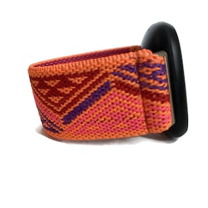 May include: A bright orange, pink, and purple woven watch band with a black watch face.