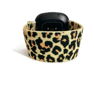 May include: A black fitness tracker with a leopard print elastic band.