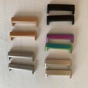 May include: Set of ten watch band strap connectors in various colors, including black, gold, silver, and iridescent.