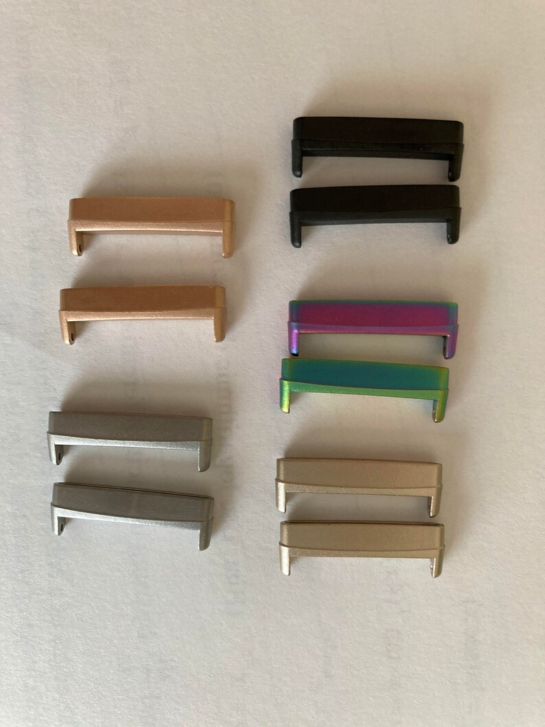 May include: Set of ten watch band strap connectors in various colors, including black, gold, silver, and iridescent.