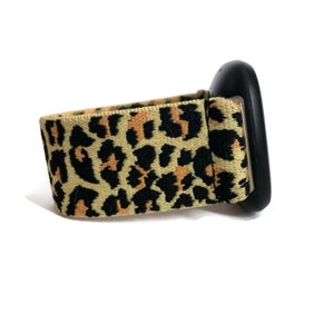 May include: A black and tan leopard print watch band with a black watch face.