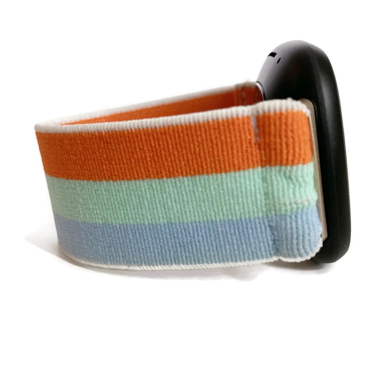 May include: A black watch with a striped orange, light green, and blue elastic band.