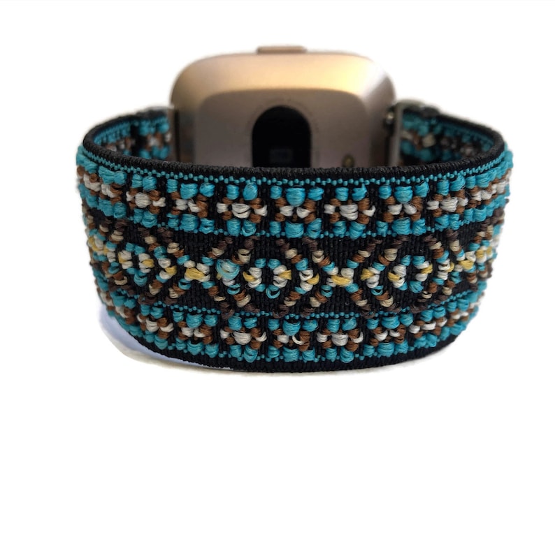 May include: A black elastic watch band with a turquoise, brown, and white geometric pattern. The band is designed for a smartwatch.