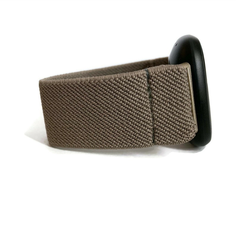 K&ouml;nnte beinhalten: Ein braunes Gummiband mit einem daran befestigten schwarzen ovalen Ger&auml;t.