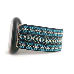 May include: A black watch band with a blue, white, and brown geometric pattern.