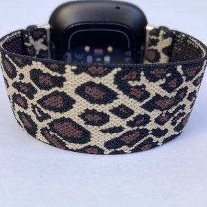 Puede incluir: Una banda el&aacute;stica para reloj inteligente con estampado de leopardo negro y marr&oacute;n.