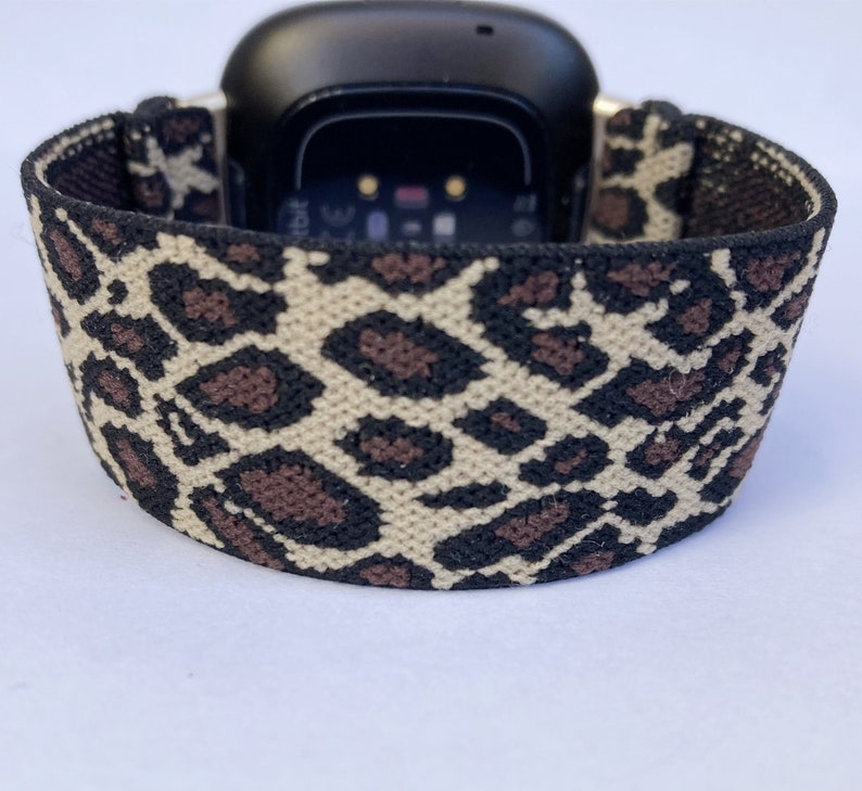 Puede incluir: Una banda el&aacute;stica para reloj inteligente con estampado de leopardo negro y marr&oacute;n.