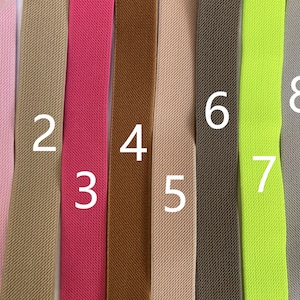 Op de afbeelding: Acht verschillende kleuren elastische stof, genummerd van 1 tot 8. De stof is een geweven, textuurmateriaal.