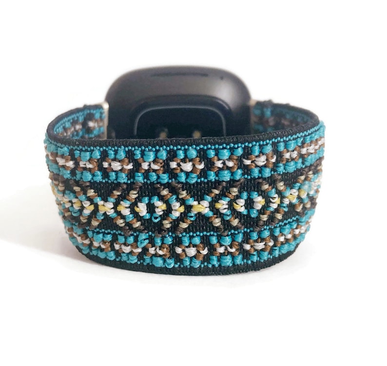 May include: A black and blue patterned watch band with a geometric design. The band is made of a soft, stretchy material.