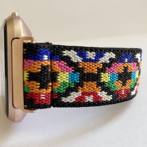 Peut inclure: Une montre connectée rose gold avec un bracelet élastique noir et multicolores.