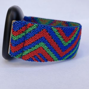 May include: A black watch band with a red, green, and blue chevron pattern.