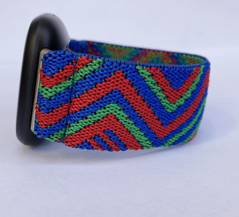 May include: A black watch band with a red, green, and blue chevron pattern.