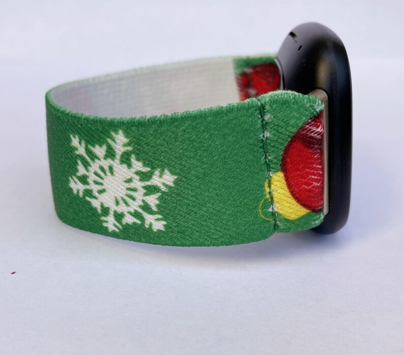 Puede incluir: Banda de reloj de Navidad verde y blanca con un copo de nieve y adornos rojos y amarillos. La banda est&aacute; hecha de un material suave y el&aacute;stico.