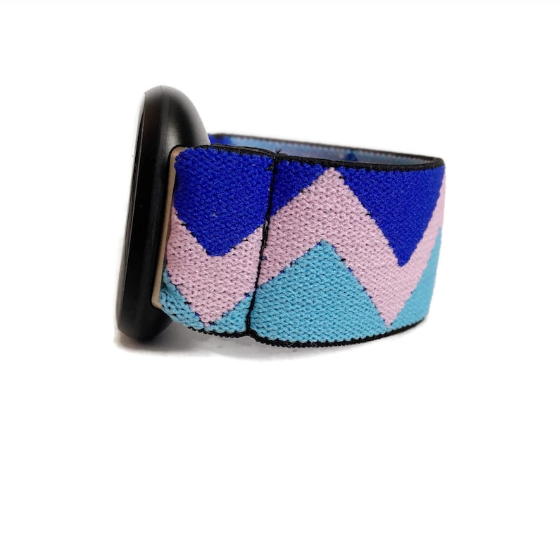 May include: A black watch with a blue, pink and light blue chevron patterned strap.