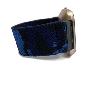 Op de afbeelding: Een blauw en zwart camouflage-patroon horlogebandje met een ros&eacute;gouden horlogewijzerplaat.