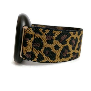 May include: A black and brown leopard print elastic watch band.