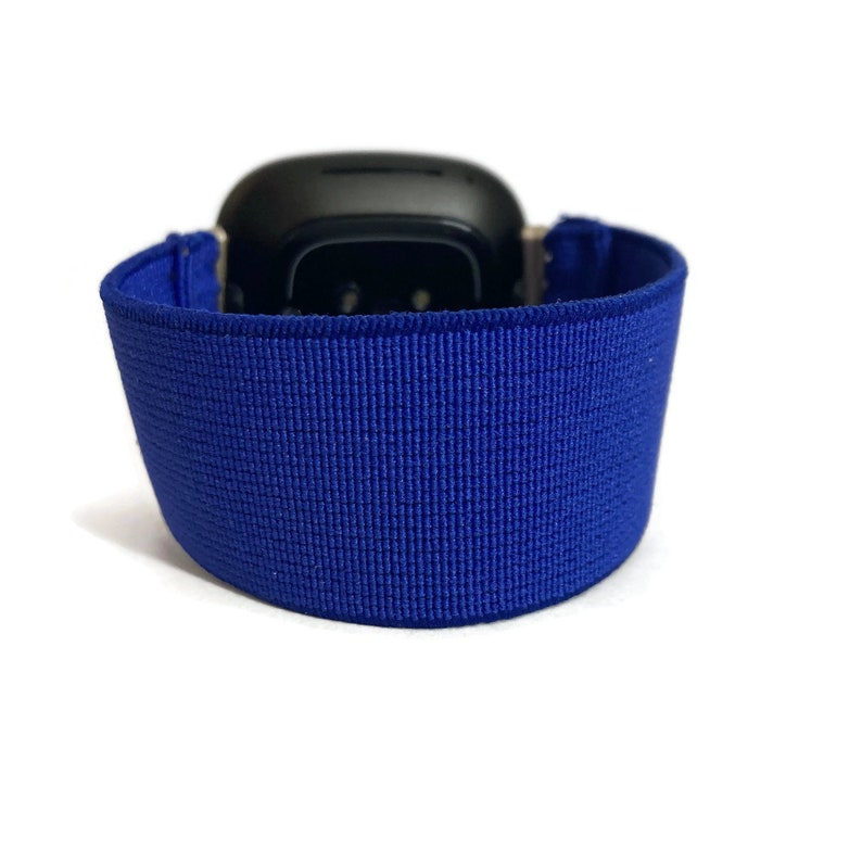 May include: A blue elastic watch strap for a smartwatch. The strap is made of a soft, stretchy material and has a smooth, even texture.