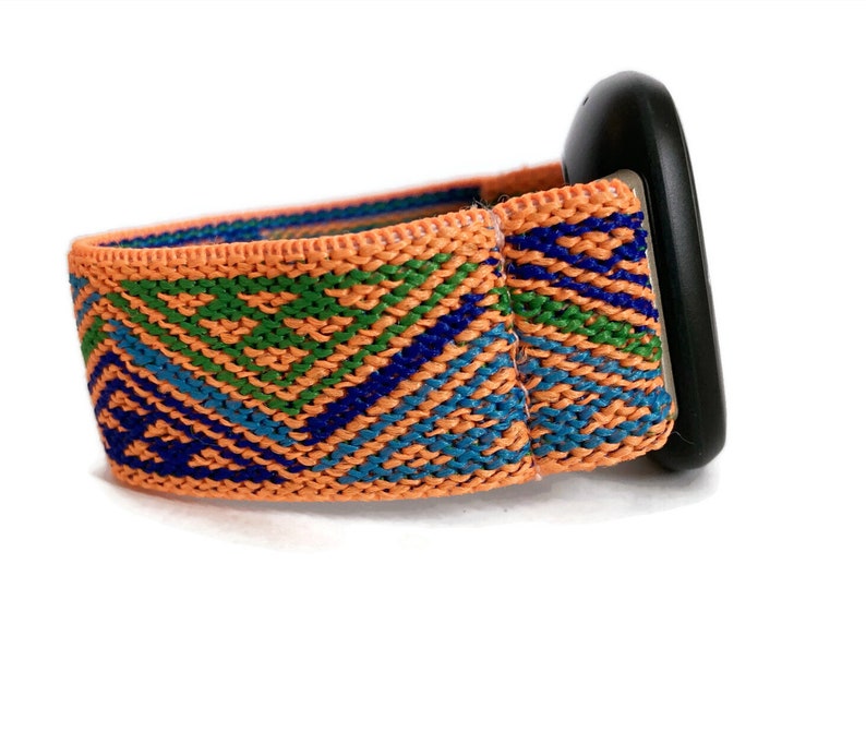 May include: A bright orange watch band with a geometric pattern in shades of blue and green. The band is made of woven fabric and has a black buckle.