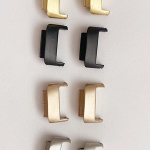 Puede incluir: Ocho pasadores de resorte para correas de reloj en cuatro colores diferentes: dorado, negro, oro rosa y plateado. Los pasadores de resorte est&aacute;n dispuestos en dos filas de cuatro.