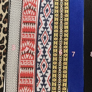 May include: Nine vertical strips of elastic webbing arranged side by side. The patterns include a colorful geometric design, leopard print, gray chevron, red and white pattern, blue and white diamond motif, gold and black weave, solid blue, solid black, and solid gray.
