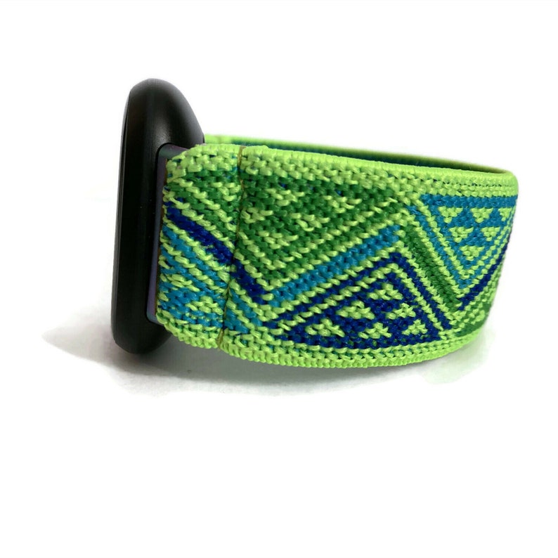 May include: A green and blue patterned watch band with a black watch face.