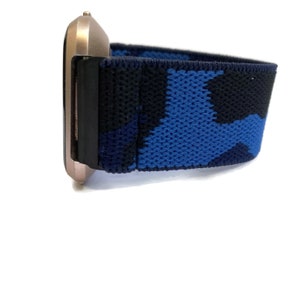 Op de afbeelding: Een blauw en zwart camouflage-patroon horlogebandje met een ros&eacute;gouden horlogewijzerplaat.