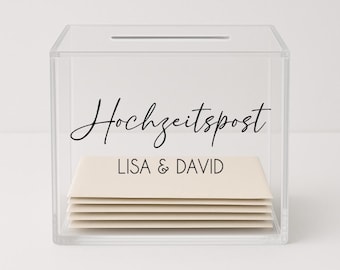 May include: A clear acrylic box with a slot on the top. The box has a black label that says "Hochzeitspost" and "LISA & DAVID".