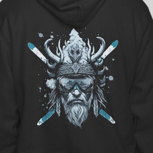 May include: Black hoodie with a graphic of a stylized figure wearing a helmet and goggles, with crossed skis behind the figure. The figure has a beard and a long, flowing mane of hair. The graphic is in shades of blue and white against a black background.
