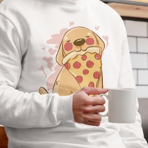 Op de afbeelding: Wit sweatshirt met een cartoonillustratie van een hond die een pizza-punt vasthoudt. De hond heeft roze wangen en is omringd door roze harten.