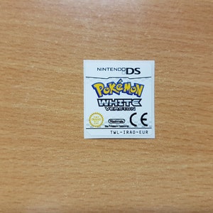 Può includere: Cartuccia di gioco bianca per Nintendo DS con sfondo bianco e il testo "Pokemon White Version" in blu e giallo. Il logo Nintendo DS è nell'angolo in alto a destra. Il gioco è classificato CE.