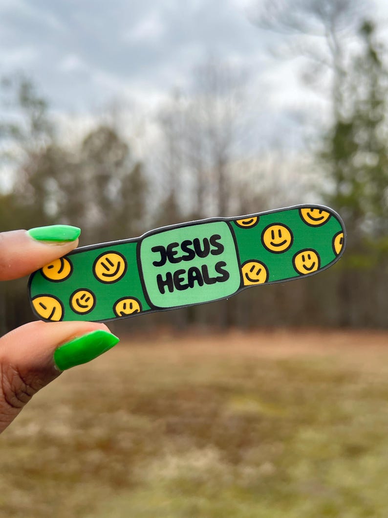 May include: Green band-aid sticker with a smiley face pattern and the text "JESUS HEALS" in black.