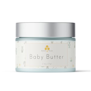 May include: A silver jar with a blue label that says "Baby Butter" and "2.5oz (71g)". The label also has a small logo with a tree and the words "Basic Plus". The jar has a white background with a pattern of small bears and stars.