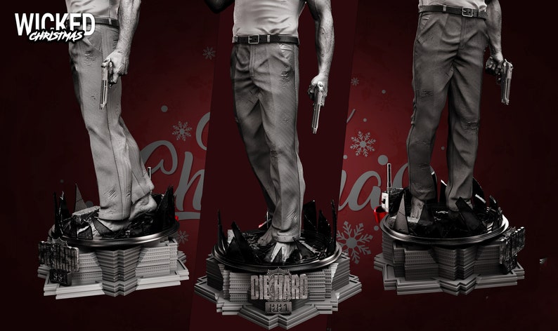 May include: A gray and white figurine of a man holding two guns, standing on a base with the words "Die Hard" and "Yippee-Ki-Yay" printed on it. The base is shaped like a building with a Christmas tree on top.